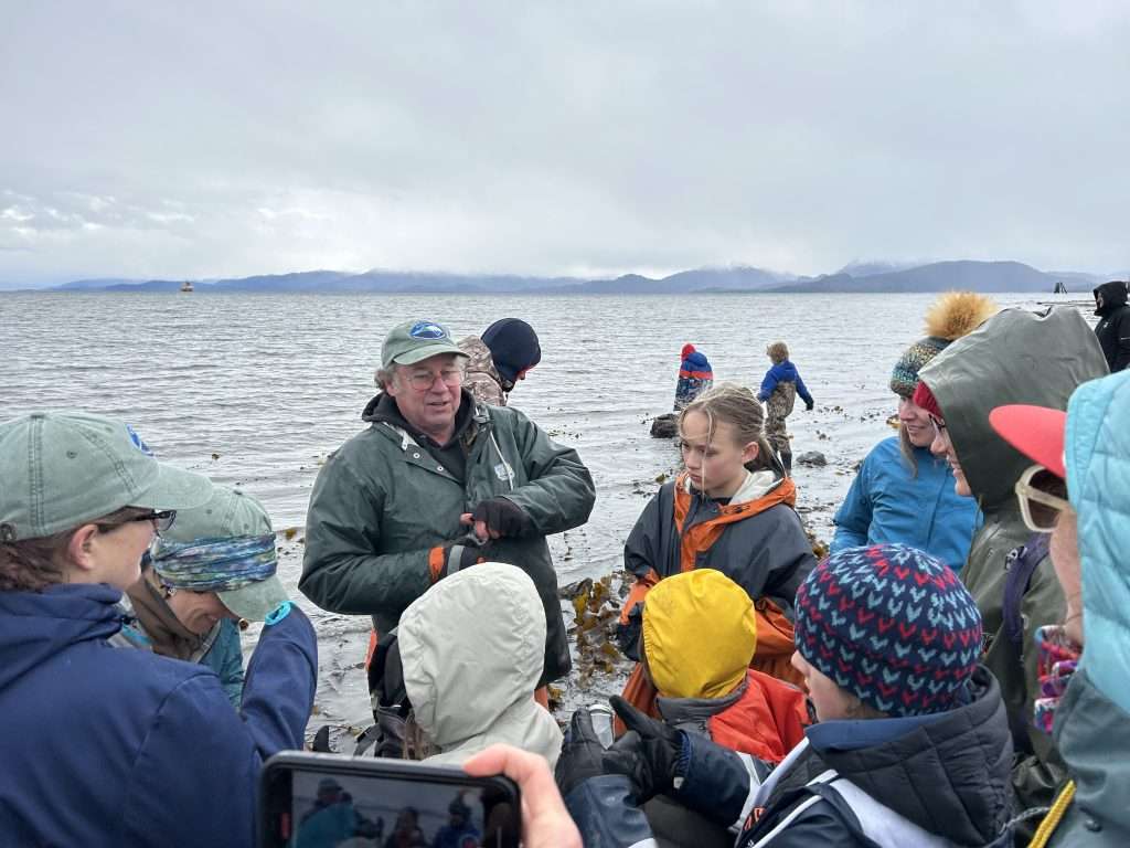 students gather on beach with education staff