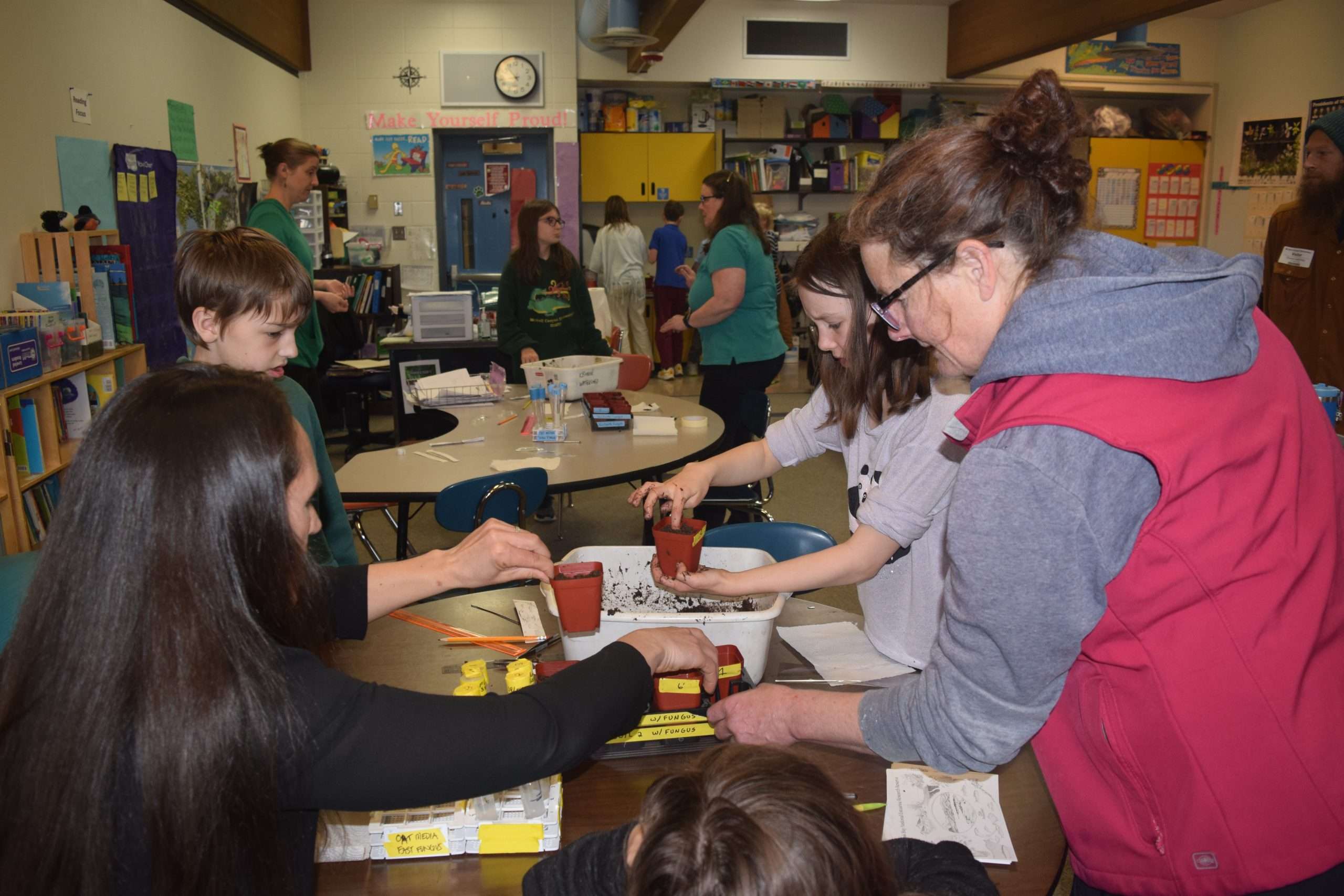 students in classroom planting orchids