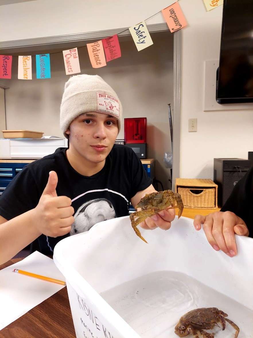 student in classroom with native crab species