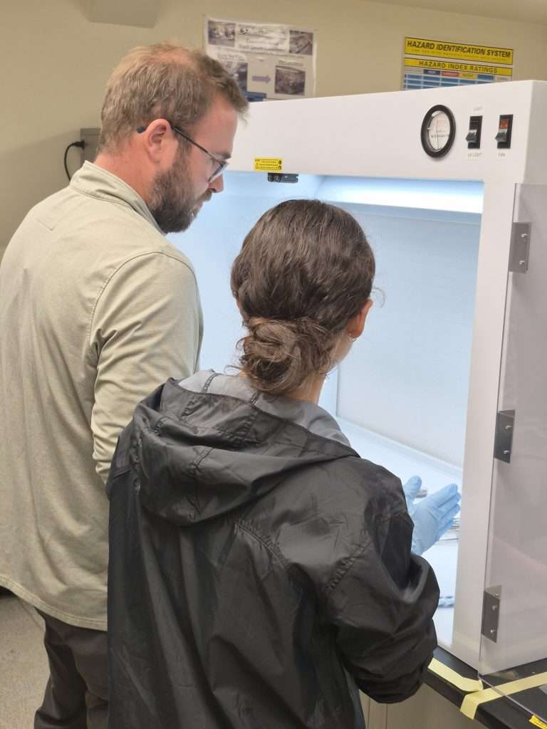 Josh learning how to work with a sterile sample using a hood