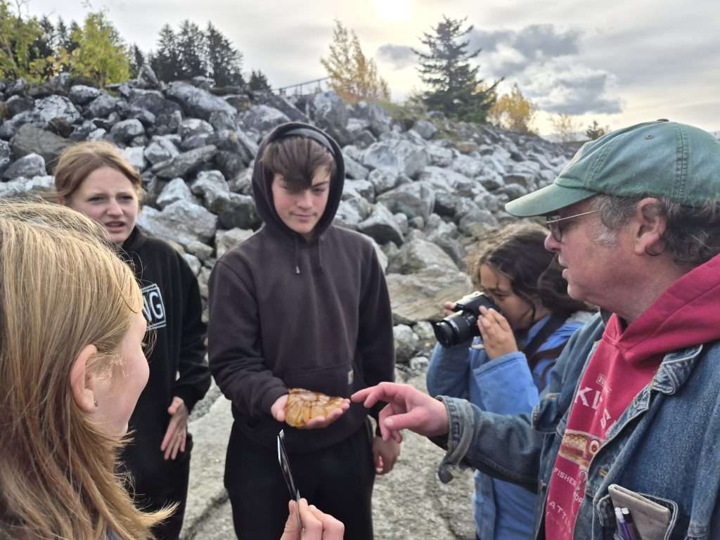 Students and instructor gather around to look at and discuss jellyfish