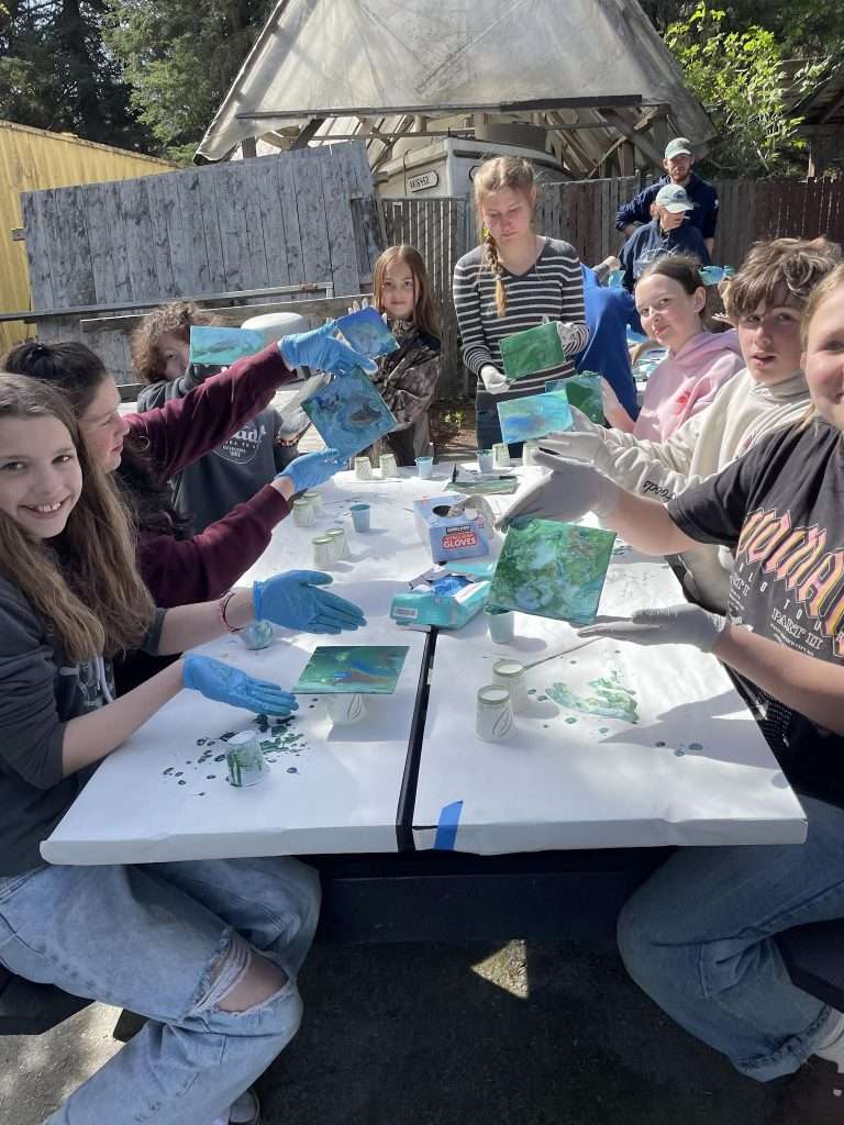 Students show estuary paintings.