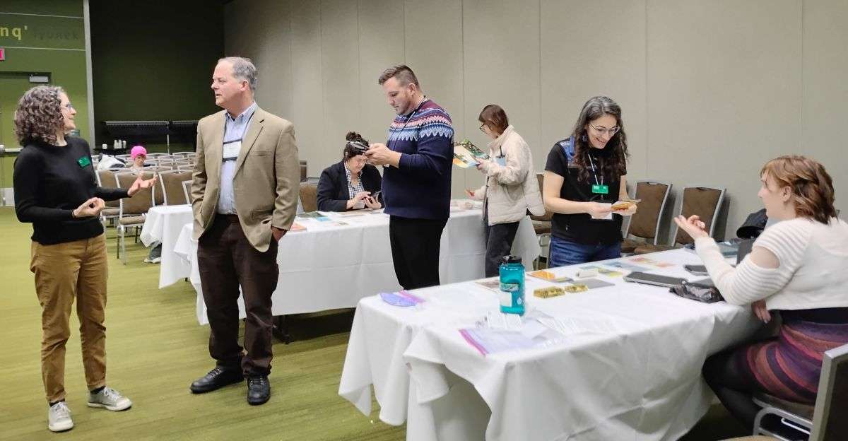 People at outreach tables learning about invasive species