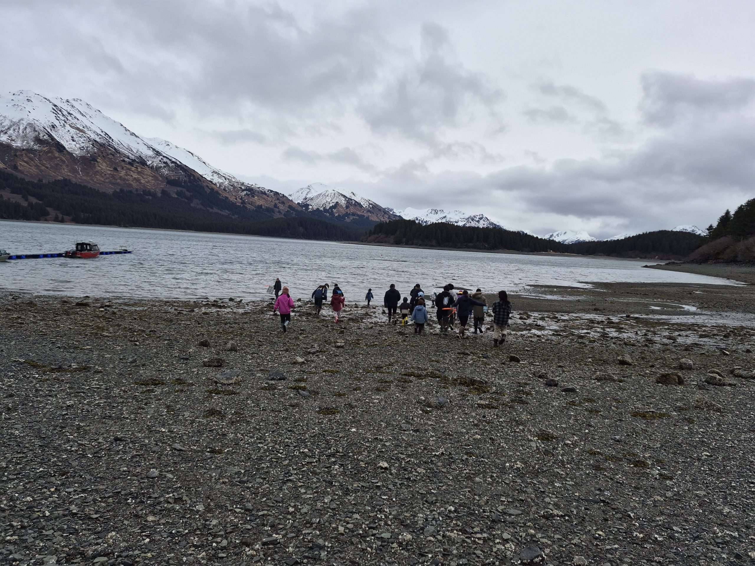 Students on beach next to ocean and mountains