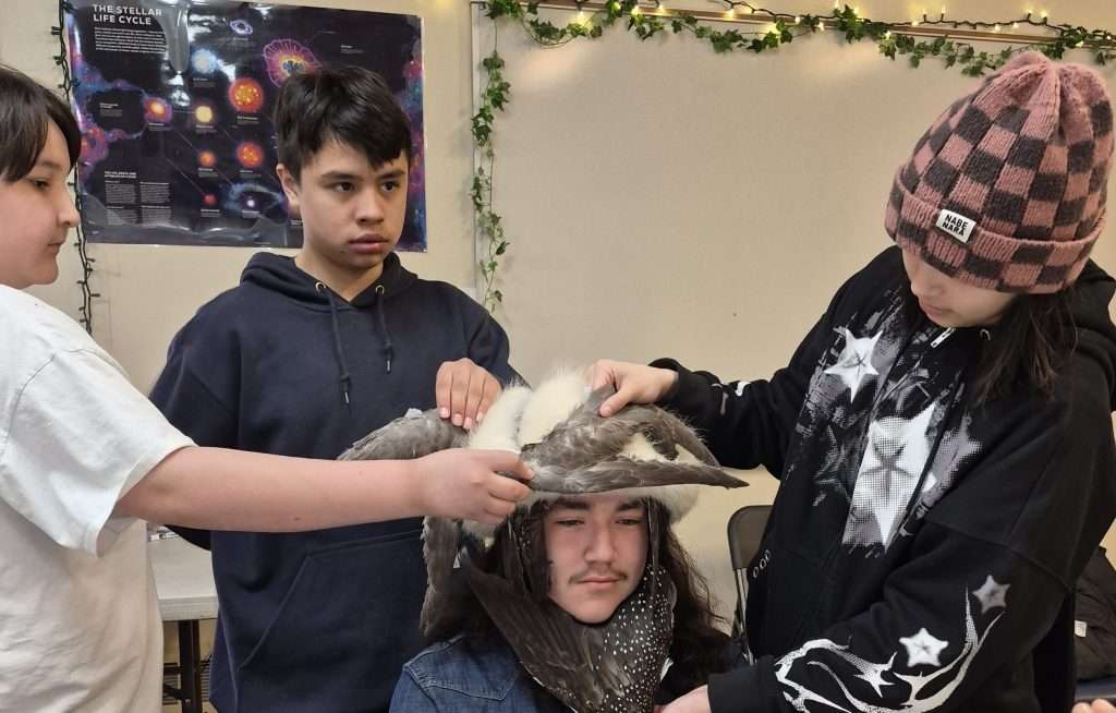 student with bird on head in classroom